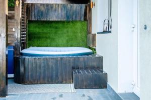 Casa Habitat في تيميشوارا: يوجد حوض استحمام على رأس جدار خشبي
