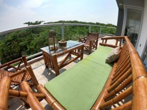 Un balcón con sillas de madera y una mesa en una terraza. en Boca PentHouses - Tampiquera en Boca del Río