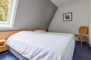 Un dormitorio con una cama blanca y una ventana. en Amelander Kaap 109, en Hollum 31 fotos más