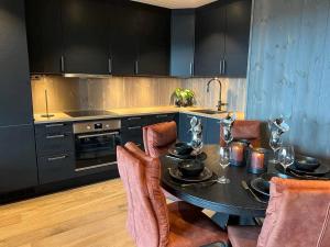 a kitchen with a table with chairs and a stove at Bualie Golsfjellet in Gol