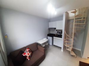 ein kleines Wohnzimmer mit einem Sofa und einer Küche in der Unterkunft Leblon Central in Rio de Janeiro