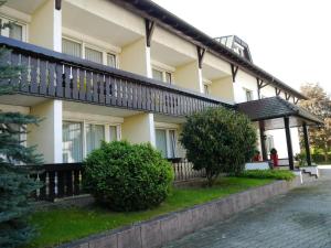 a large white building with a black balcony at Hotel Schwan in Hügelsheim