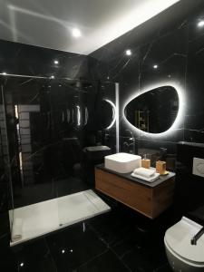 a black bathroom with a sink and a mirror at Proche mer, vieille ville. Luxueux appartement in Villefranche-sur-Mer +3 photos