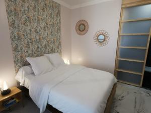 1 dormitorio con cama blanca y pared en Proche mer, vieille ville. Luxueux appartement en Villefranche-sur-Mer