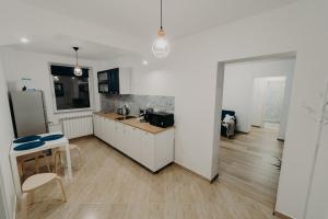 a white kitchen with a counter and a table at Apartamentul Albastru in Vatra Dornei