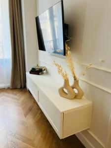 un mobile bianco con dei vasi sopra in una stanza di DELUXE APARTMENT NEAR GRAN VIA a Madrid