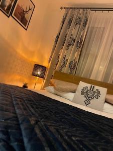 sypialnia z łóżkiem z czarną kołdrą i oknem w obiekcie Apartament Krupówki Centrum w Zakopanem