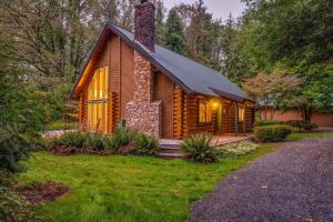 a log cabin in the woods with the lights on at The Fernwood in Brightwood