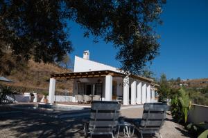 eine weiße Kirche mit Stühlen davor in der Unterkunft Casa Calmante - Stunning 3-bedroom Villa with Private Pool in Cómpeta