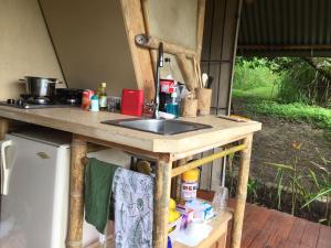 a kitchen counter with a sink and a refrigerator at Glamping El Árbol en la Casa in San Antonio del Tequendama