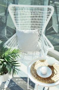 a white wicker chair with a table on a porch at Old Town Walowa in Gdańsk