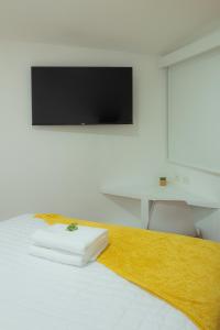 危地馬拉的住宿－Cozy Apartment I，卧室配有一张壁挂式平面电视的床。