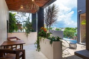 a patio with a table and chairs and plants at UJO Condo Boutique in Tulum