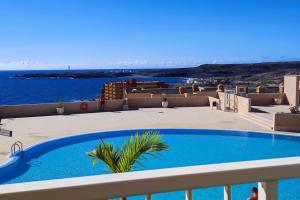 - une piscine sur un balcon avec l'océan en arrière-plan dans l'établissement Beach and pool view , 4 people, and free wifi, à Poris de Abona