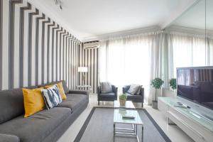 - un salon avec un canapé et une télévision dans l'établissement AmazINN Places Atocha Deluxe I, à Madrid