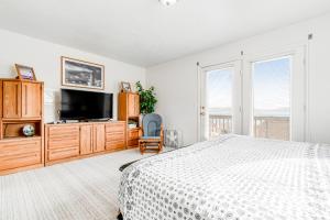 a bedroom with a bed and a flat screen tv at Marina Retreat in Garden City