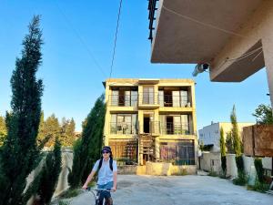 a woman riding a bike in front of a building at Smile Guesthouse in Tbilisi City