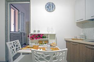 een keuken met een tafel en stoelen bij Le Volte Apartments in Torchiarolo