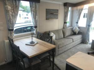 a living room with a table and a couch at Flamingo Land Private Caravan - No 8 Cedarwood in Kirby Misperton