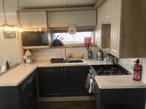 a kitchen with a sink and a stove top oven at Flamingo Land Private Caravan - No 8 Cedarwood in Kirby Misperton