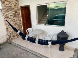 カボ・フリオにあるCasa Duplex 2 quartos com amplo quintalのパティオ(テーブル、椅子、窓付)