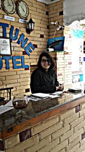 a woman sitting at a counter in a brick wall at Neptune Hotel in Dahab
