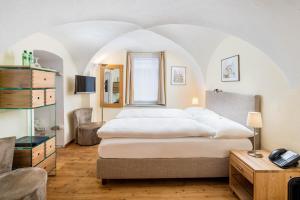 - une chambre avec un grand lit blanc et une table dans l'établissement Hotel Engadinerhof Superior, à Pontresina