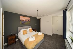 a bedroom with a large bed with two towels on it at Pinfold Suite - Chester Road Apartments By in Macclesfield