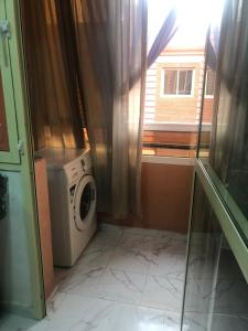 a laundry room with a washing machine and a window at Appartement cosy et discret in Marrakesh