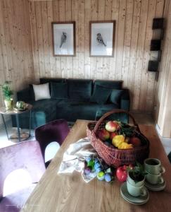 Sala de estar con mesa y cesta de fruta en Kwitnące Jabłonie. Całoroczne Domki Wypoczynkowe en Obrazów