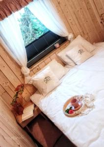 uma cama num quarto com uma janela e um prato de comida em Kwitnące Jabłonie. Całoroczne Domki Wypoczynkowe em Obrazów