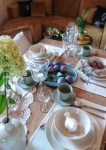 stół z talerzami i kieliszkami do wina w obiekcie Kwitnące Jabłonie. Całoroczne Domki Wypoczynkowe w mieście Obrazów