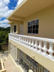 a balcony of a house with a white railing at Ultimate Chill Brown's Town in Browns Town