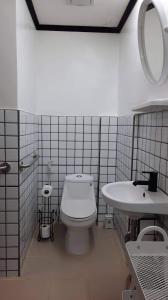 a bathroom with a white toilet and a sink at Pretty flat with full AC 