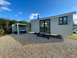 a tiny house with a shed and a bench at The Shepherd’s Nest in Bristol