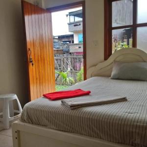 a bed with a red towel on it with a window at OCEANSURF hosteria in Mompiche +43 photos