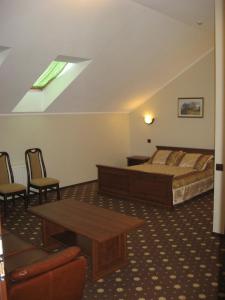 1 dormitorio con 1 cama, mesa y sillas en Shato Paradis Hotel, en Irpín