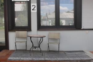 2 sillas y una mesa en una habitación con 2 ventanas en Looks Inn, en Heidelberg