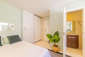una camera con un letto bianco e una pianta di AmazINN Places Gran Via III a Madrid