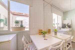 una sala da pranzo bianca con tavolo e sedie bianchi di AmazINN Places Gran Via III a Madrid