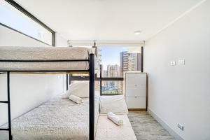Un dormitorio con dos literas y una ventana. en Galerna Home 2BR W/Balcony, Wifi & Parking., en Concón 14 fotos más