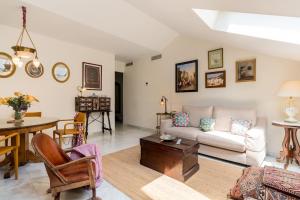 salon z kanapą i stołem w obiekcie Apartamentos RG, San Vicente 22 w Sewilli