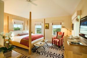 a bedroom with a bed and a desk and a television at White Elephant Hotel in Nantucket