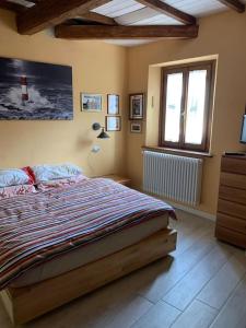 a bedroom with a large bed and a window at Confortevole casa di montagna- La Campana in San Marcello Pistoiese