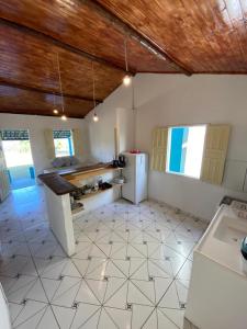 a kitchen with a refrigerator and a tile floor at OCA Caraíva in Caraíva