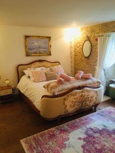 a dog laying on a bed in a bedroom at Maison Blanche De Hudson in Cussac