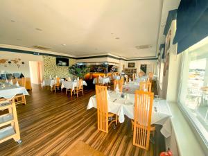 un restaurant avec des tables et des chaises blanches dans une salle dans l'établissement Hawk House, à West Camel