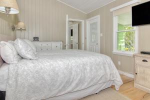 a bedroom with a white bed and a window at SeaSpray Beach Cottage A in St. Pete Beach