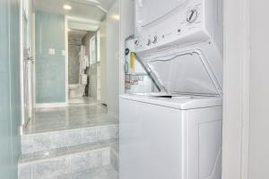 a white washing machine in a bathroom with a shower at SeaSpray Beach Cottage A in St. Pete Beach