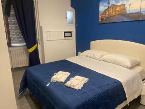 ein blaues Schlafzimmer mit einem Bett mit zwei weißen Hemden darauf in der Unterkunft Giulieda in Wonderland in Neapel